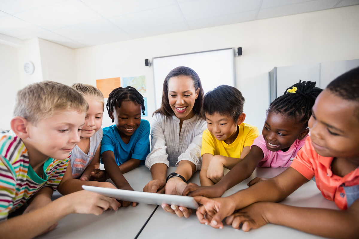 teacher reviewing instructional materials with students on a tablet