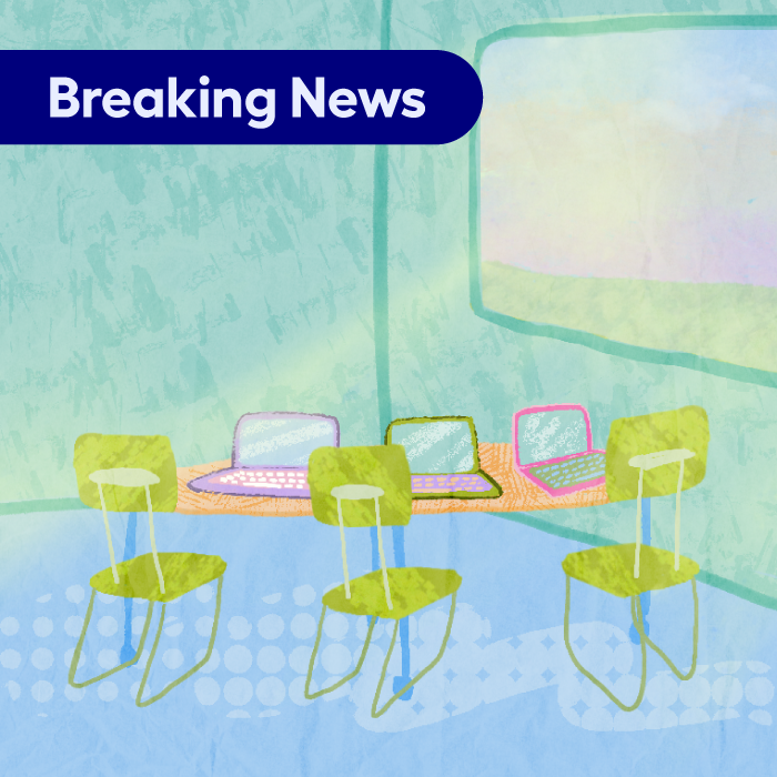 Image of a classroom with a small group of chairs and computers